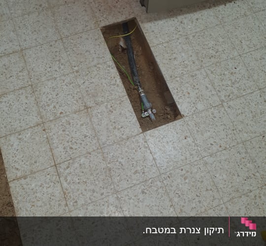 צינור מים חשוף ברצפה עם חיבורי אינסטלציה